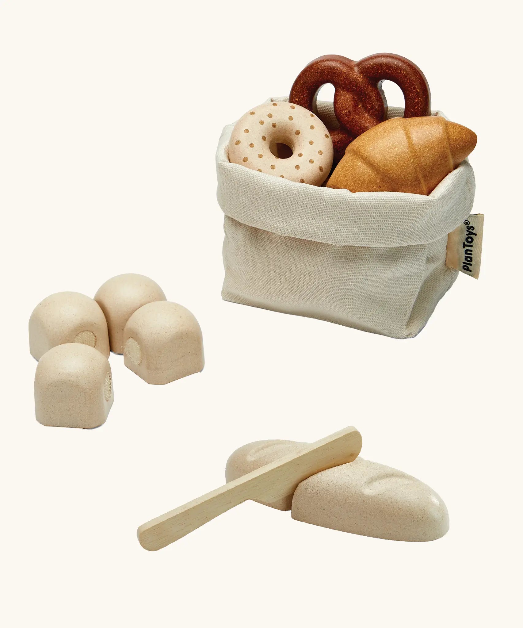 Open cotton bag filled with pretend pastries from the PlanToys bread play set 