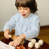 Child playing with a pretend pastry from the PlanToys bread play set