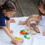 Children playing with different play wood pieces from the PlanToys breakfast menu set