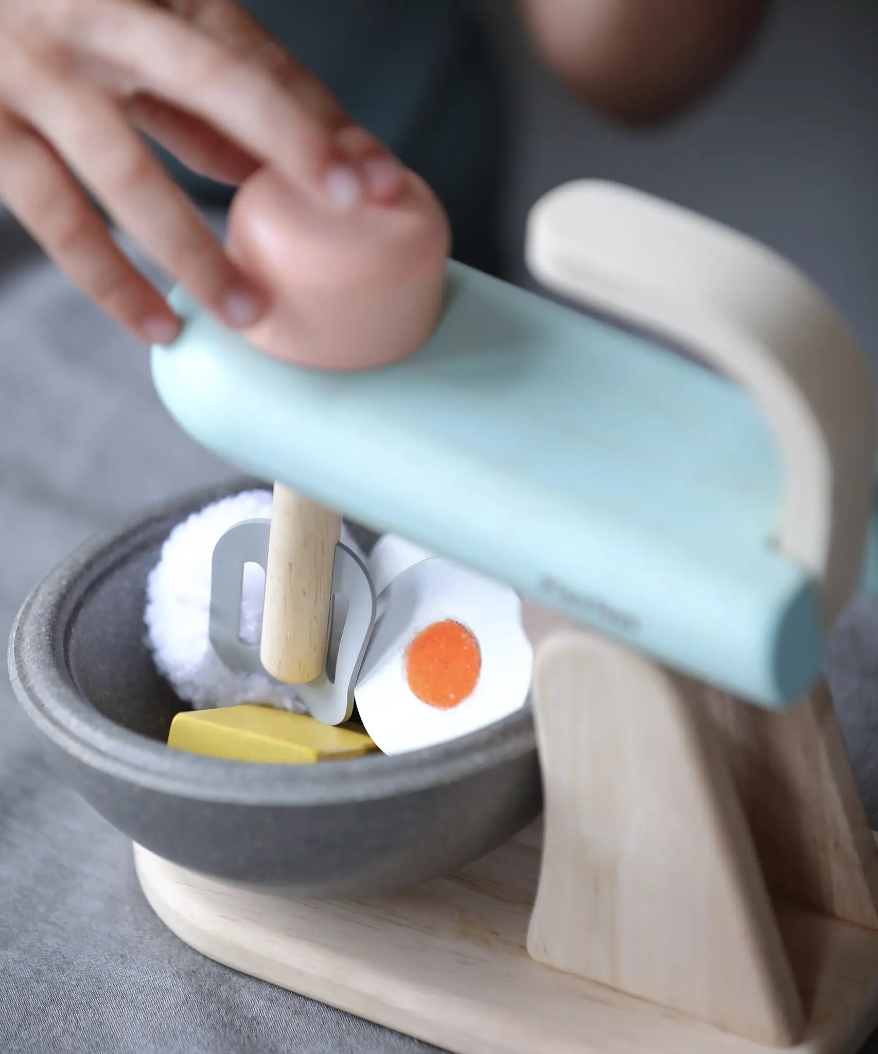 Plan Toys cake mixer play set showing a close up of the grey bowl filled with wooden play food