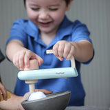 Child holding on the working mixer from the PlanToys cake mixer play set on a bowl