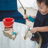 Child cleaning a table using tools from the PlanToys cleaning set