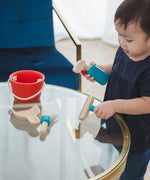 Child cleaning a table using tools from the PlanToys cleaning set