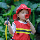 Child playing with the PlanToys fire fighter set wearing the vest, hat and holding the hose and mega phone