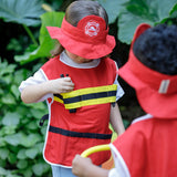 A child reaching for a walkie talkie inside a pocket on vest from the PlanToys fire fighter pretend play set
