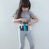 Child wearing the waist bag with accessories from the Plan Toys hair dresser set 