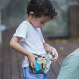 Child wearing the waist bag from the PlanToys hair dresser set with different accessories 