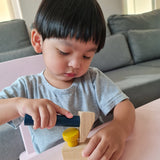 A close up of a child playing with the hammer from the Plan Toys wooden handy carpenter set available at Babipur