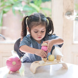 Child stacking different coloured ice cream scoops from the PlanToys wooden ice cream play set