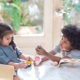 Children playing with the PlanToys wooden ice cream play set