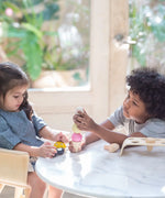 Children playing with the PlanToys wooden ice cream play set