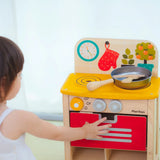 Child closing the oven door on the PlanToys kitchen set