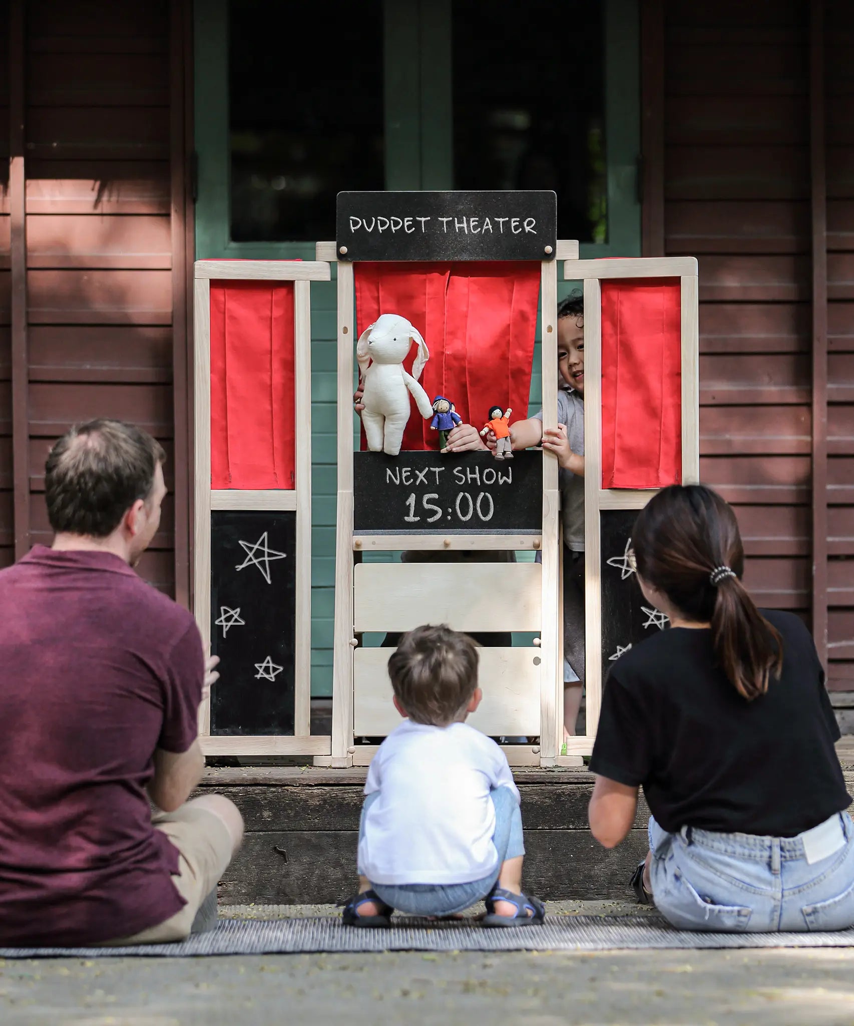 Children playing with the PlanToys play centre made into a puppet show