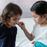 Child playing with the lipstick from the PlanToys make up set