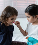 Child playing with the lipstick from the PlanToys make up set
