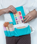 Child wearing the blue waist bag filled with tools and accessories from the PlanToys make up set