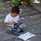 Child playing with the PlanToys secret agent play set on a wooden surface
