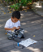 Child playing with the PlanToys secret agent play set on a wooden surface