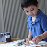 Child playing with the PlanToys wooden shaving set on a table 