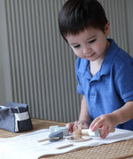 Child playing with the PlanToys wooden shaving set on a table 