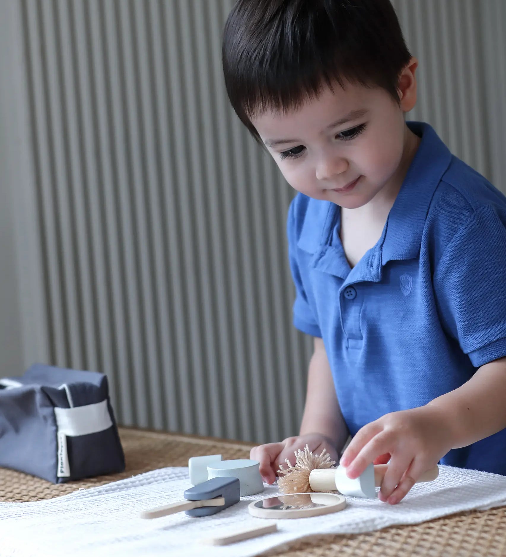 Child playing with the PlanToys wooden shaving set on a table 