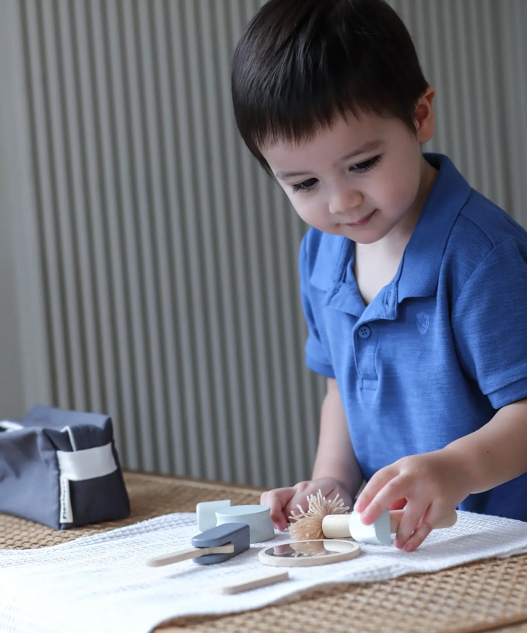 Child playing with the PlanToys wooden shaving set on a table 
