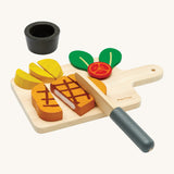 Plan Toys wooden steak set available at Babipur. Set includes a steak to cut, tomato, chips, a pot for the chips,  knife and a cutting board