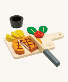 Plan Toys wooden steak set available at Babipur. Set includes a steak to cut, tomato, chips, a pot for the chips,  knife and a cutting board