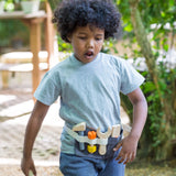 Child wearing a PlanToys tool waist play belt in the garden