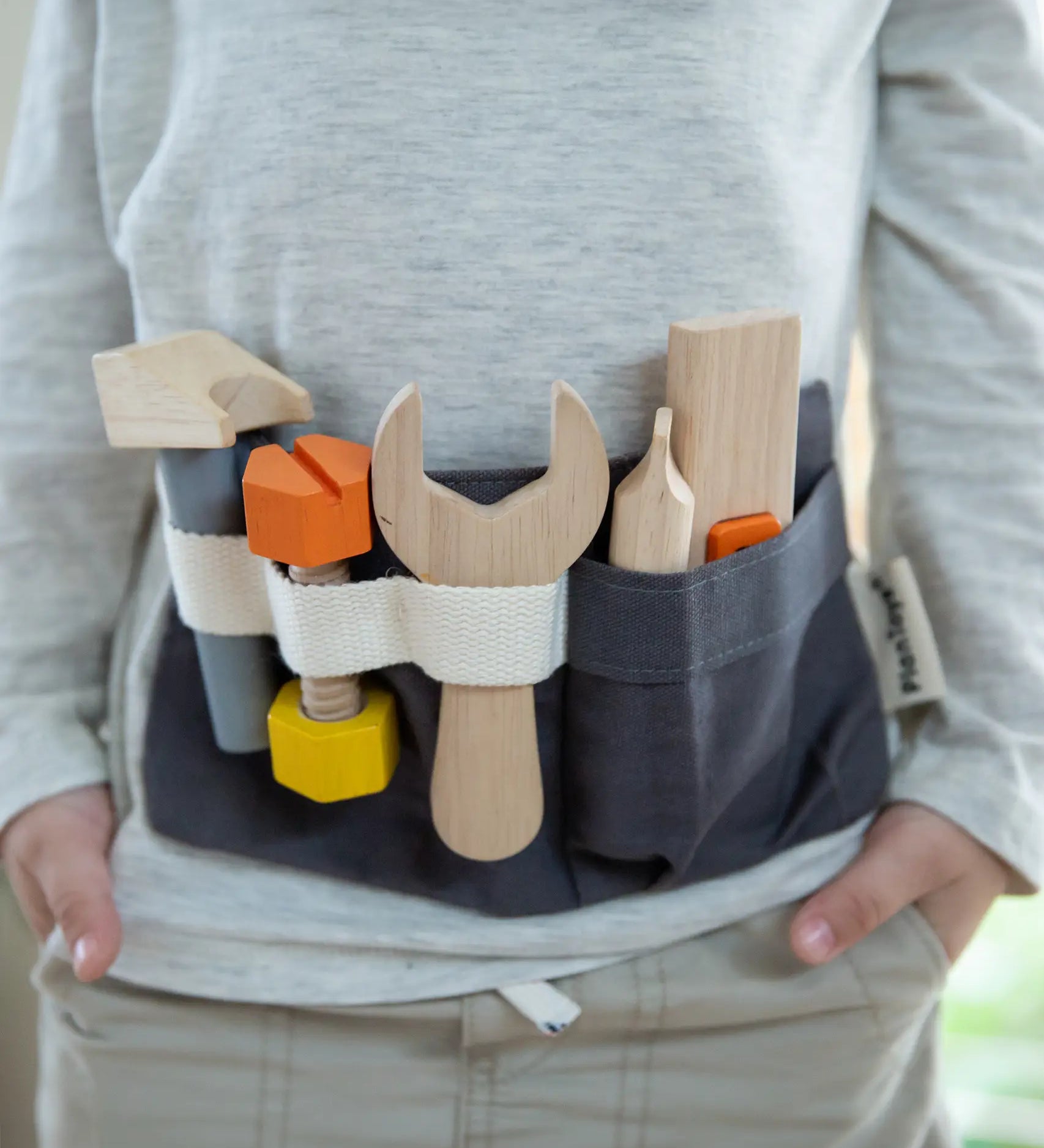 Front of child wearing the PlanToys toys tool belt 