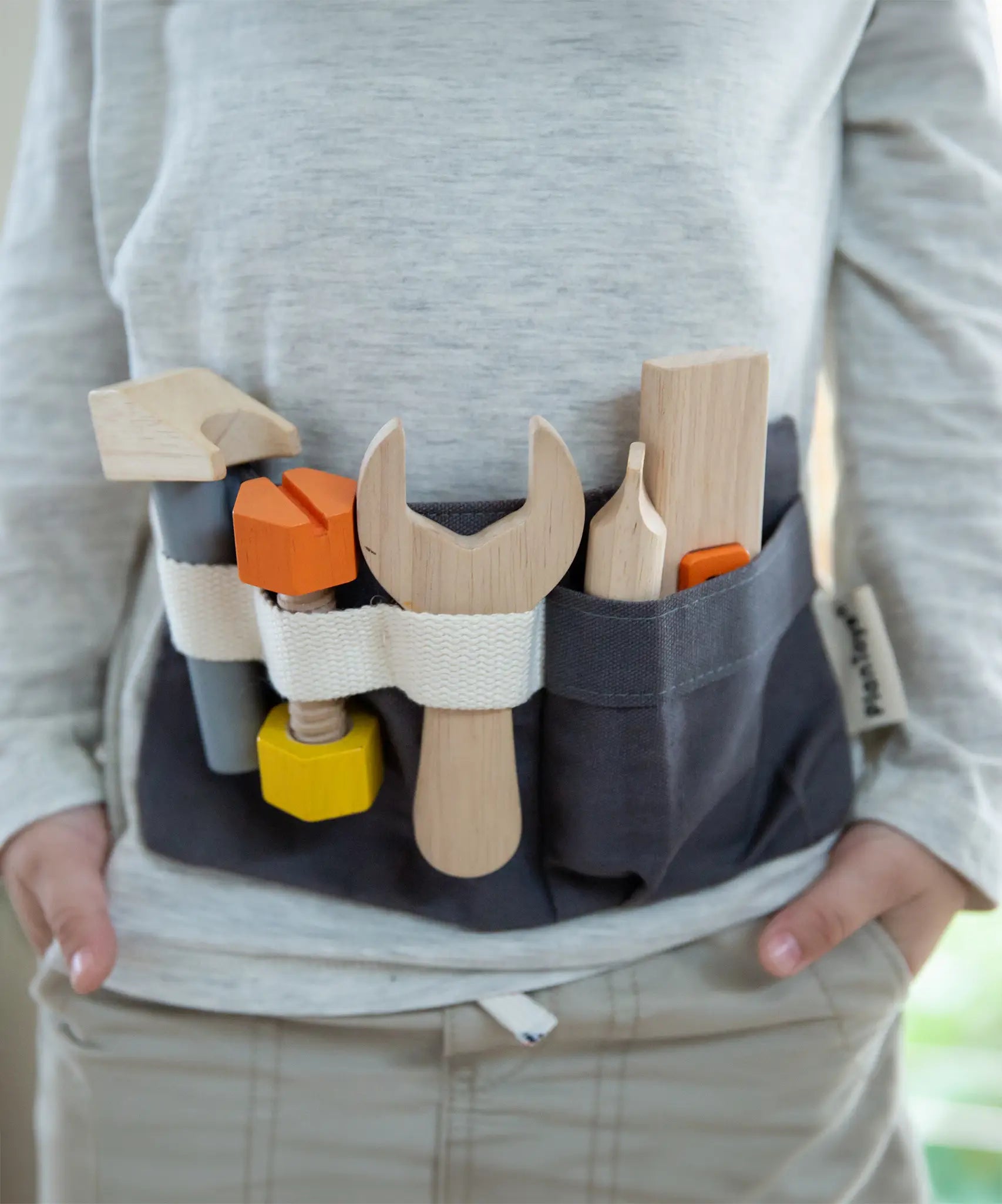 Front of child wearing the PlanToys toys tool belt 