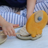 Child picking up a pretend waffle from the PlanToys wooden waffle maker 
