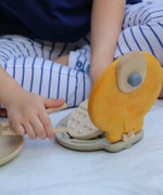 Child picking up a pretend waffle from the PlanToys wooden waffle maker 