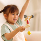 Child playing with the PlanToys Weightlifting Acrobat wooden toy.