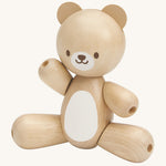 This PlanToys Bear is a sweet wooden toy that will be loved by babies and toddlers. This wooden baby toy bear has legs and arms that move around, a white tummy patch and a happy and smiling face. The image is on a cream background
