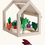 PlanToys wooden blooming greenhouse frame with different veg inserted inside sorting pieces showing a loose red cabbage piece