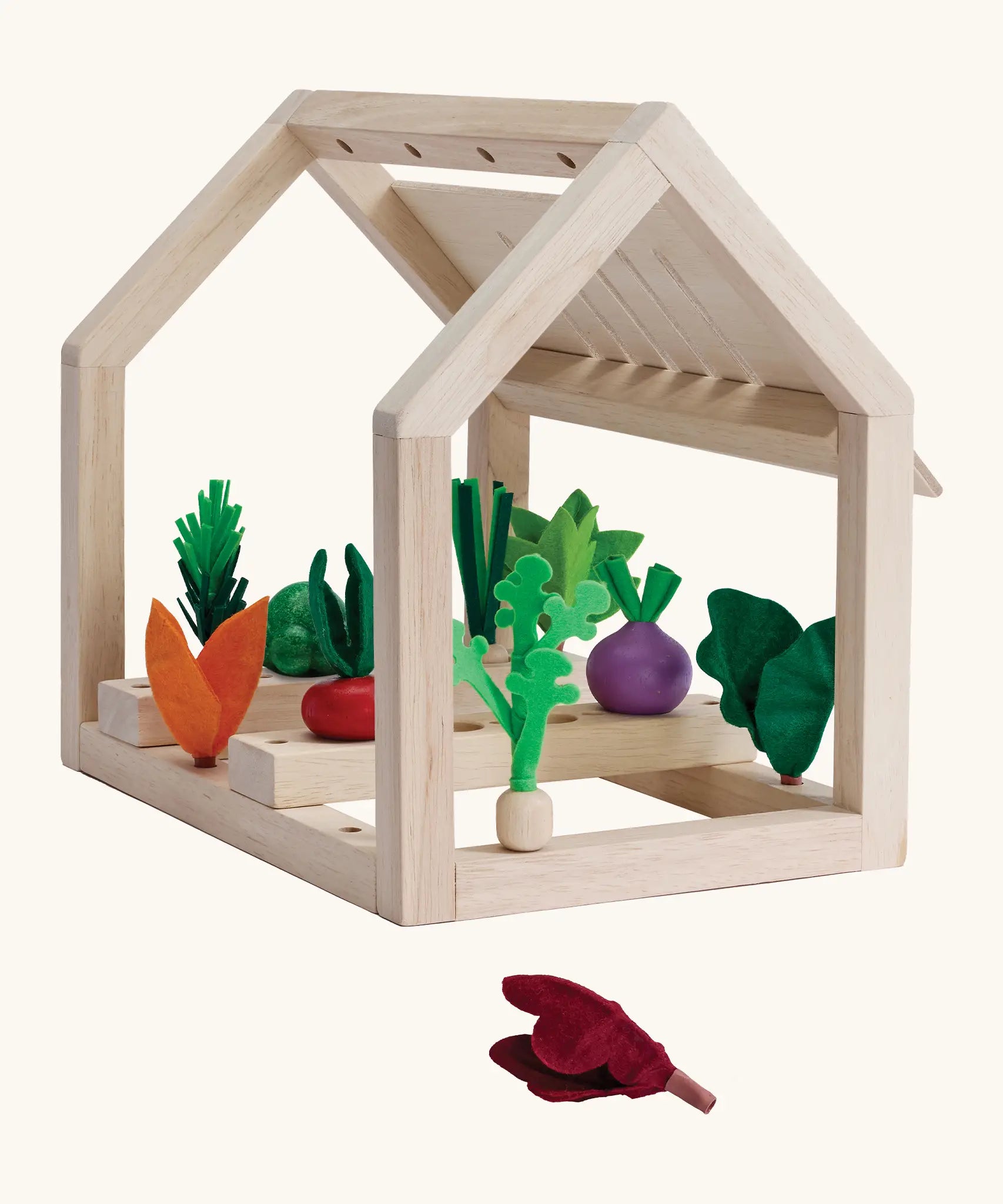 PlanToys wooden blooming greenhouse frame with different veg inserted inside sorting pieces showing a loose red cabbage piece