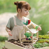 Child sorting different veg pieces on the PlanToys wooden blooming greenhouse 