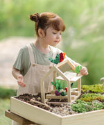 Child sorting different veg pieces on the PlanToys wooden blooming greenhouse 