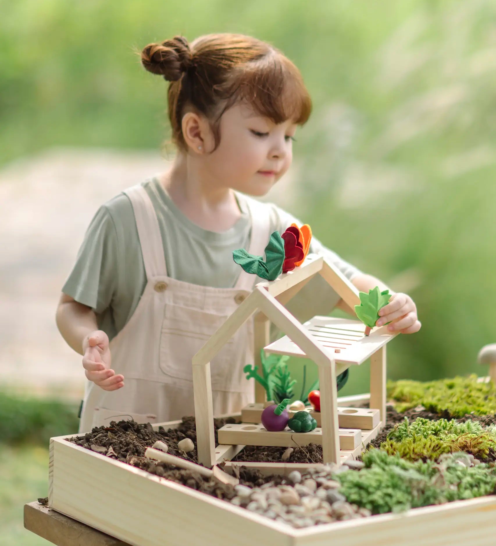 Child sorting different veg pieces on the PlanToys wooden blooming greenhouse 