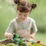 Child sorting loose veg pieces on planting beds from the PlanToys stack & sprout set