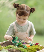 Child sorting loose veg pieces on planting beds from the PlanToys stack & sprout set