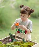 Child sorting different pieces on the PlanToys stack and sprout set on a large planter