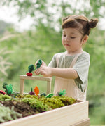 Child inserting veg pieces on planting beds from the PlanToys stack & sprout set