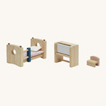 The PlanToys Bedroom Furniture lined up in a row, showing the bottom bunk bed section, the writing desk and the chair on a cream background