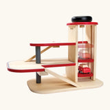 PlanToys wooden city parking garage. showing a car on the working wind up lift