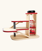 PlanToys wooden city parking garage. showing a car on the working wind up lift
