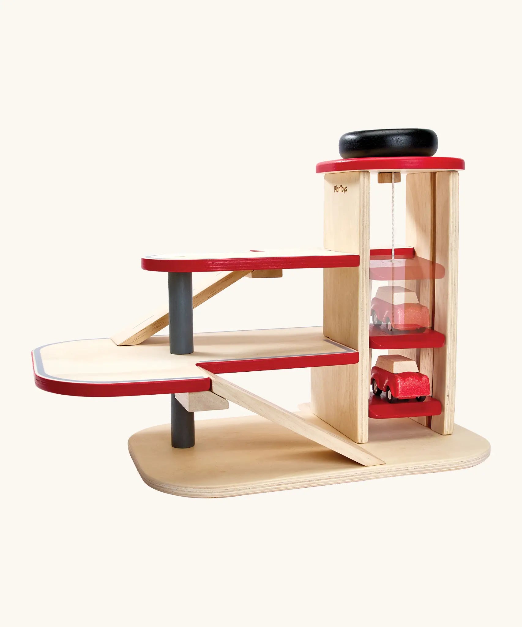 PlanToys wooden city parking garage. showing a car on the working wind up lift