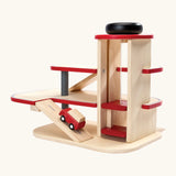 PlanToys wooden city parking garage showing a red vehicle going up a ramp