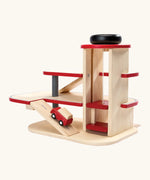 PlanToys wooden city parking garage showing a red vehicle going up a ramp